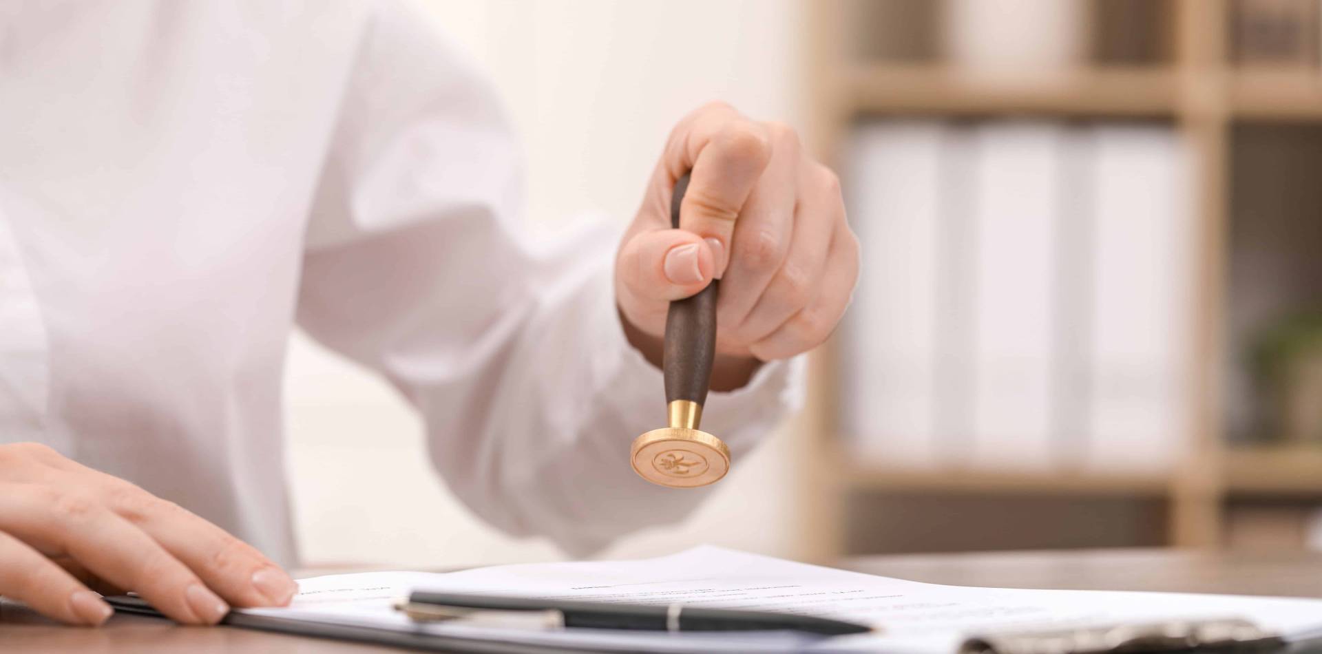 Woman Stamping Document At Table, Closeup View